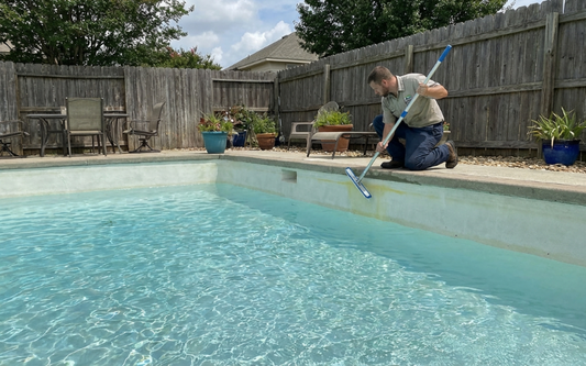 Person inspecting pool stains in a full swimming pool without draining the water