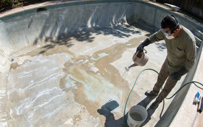 Acid washing a drained pool with protective gear and cleaning solution