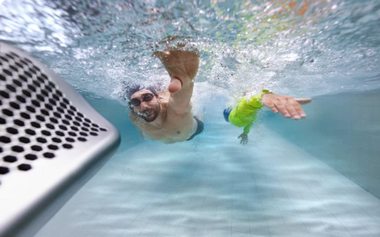 a swimmer swimming in place against a current in a residential inground pool